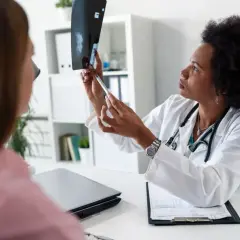 Lekarka omawia z pacjentką wynik mammografii, wskazując na zmiany. BIRADS 5 rokowania wymaga dalszej diagnostyki.
