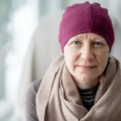 Kobieta w bordowej chuście i beżowym szalu, zmagająca się z rakiem luminalnym B (HER2 dodatni).