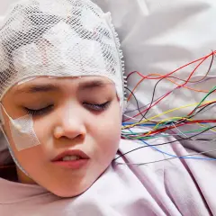 Dziecko z czepkiem EEG, badanie może pomóc wykryć objawy guza mózgu u dzieci.