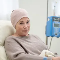 Kobieta w czepku na głowie, podczas terapii, z nadzieją na najdłuższe przeżycie ze szpiczakiem.