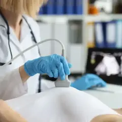 Lekarz wykonuje USG piersi, badanie które pomoże sprawdzić, czy zwapnienia w piersiach bolą.