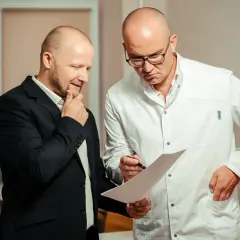 Lekarz w białym kitlu omawia z pacjentem wyniki badań, analizując rokowania dotyczące raka cewki moczowej.