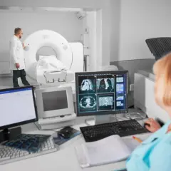 Lekarz nadzoruje badanie tomografem komputerowym, podczas gdy technik analizuje obrazy na monitorze. Czy tomografia komputerowa wykryje raka?
