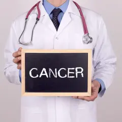 Lekarz w białym kitlu trzyma tabliczkę z napisem "CANCER". Co to znaczy nowotwór low grade?