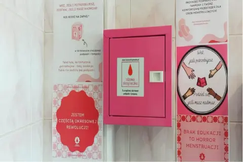 Różowa skrzynka z darmowymi środkami higienicznymi. Napisy zachęcają do dzielenia się, gdy masz nadmiar. To część "okresowej rewolucji", która walczy z brakiem edukacji.