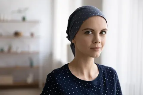 Młoda kobieta w chustce na głowie, symbolizująca siłę i nadzieję przed chemioterapią.