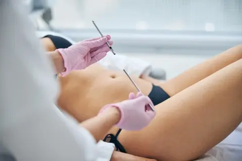 Lekarz w różowych rękawiczkach trzyma narzędzia do biopsji. Czy biopsja gruboigłowa oznacza raka? To badanie diagnostyczne, nie wyrok.