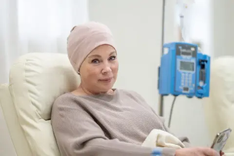 Kobieta w czepku na głowie, podczas terapii, z nadzieją na najdłuższe przeżycie ze szpiczakiem.