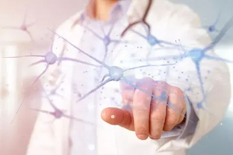 Lekarz dotyka wirtualnych neuronów, symbolizując nadzieję dla ludzi po chemioterapii na regenerację układu nerwowego.