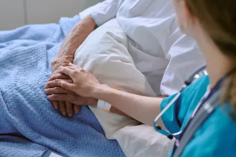 Dłoń pielęgniarki na dłoni pacjenta, symbol wsparcia w leczeniu. Terapia celowana daje nadzieję.
