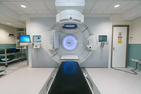 Nowoczesny akcelerator liniowy do radioterapii. Pacjent leży na stole, a maszyna precyzyjnie naprowadza wiązkę. Co gorsze chemioterapia czy radioterapia?