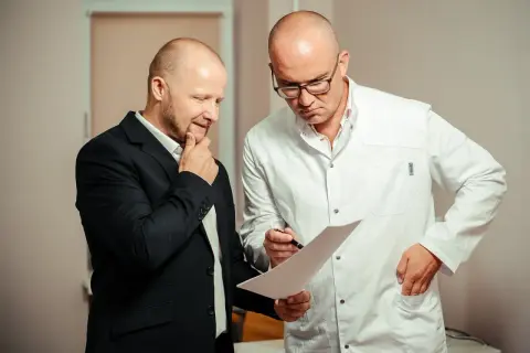 Lekarz w białym kitlu omawia z pacjentem wyniki badań, analizując rokowania dotyczące raka cewki moczowej.