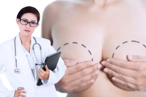 Lekarka w białym kitlu z notatnikiem analizuje piersi z zaznaczonymi liniami, sugerującymi diagnostykę mikrozwapnień w piersiach.