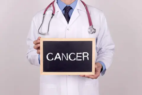 Lekarz w białym kitlu trzyma tabliczkę z napisem "CANCER". Co to znaczy nowotwór low grade?